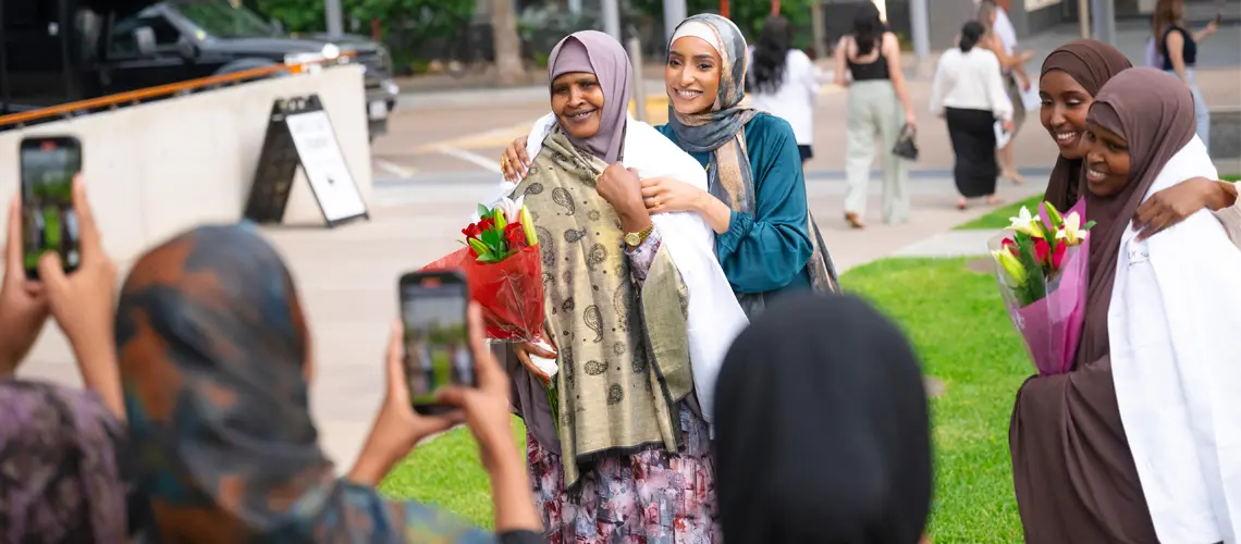 Female students placed their white coats over the shoulders of female family members